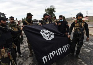 Iraqi soldiers pose with an Islamic State (IS) group flag as they hold a position in the village of Gogjali, a few hundred metres of Mosul's eastern edge, on November 2, 2016, as clashes go on between Iraqi army forces and the jihadists to retake Mosul, the last Iraqi city under the control of IS. / AFP / BULENT KILIC (Photo credit should read BULENT KILIC/AFP/Getty Images)